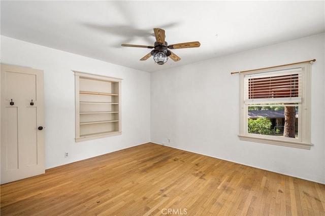 spare room featuring ceiling fan, hardwood / wood-style floors, and built in features