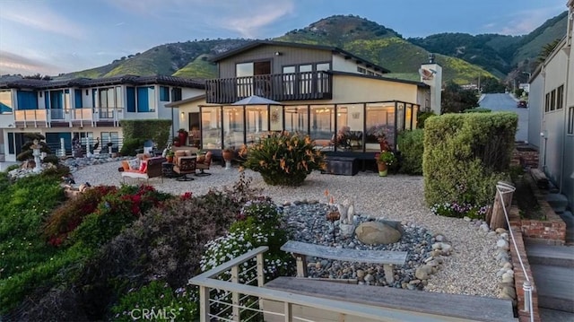 rear view of property featuring a mountain view and a balcony