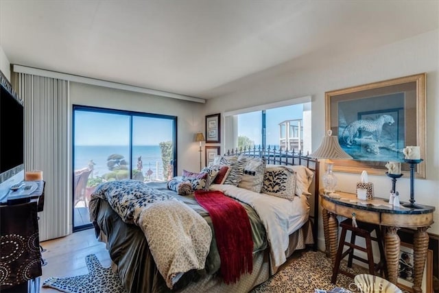 bedroom with hardwood / wood-style floors and a water view