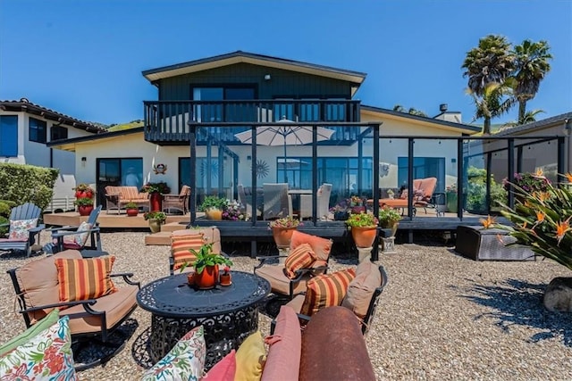 rear view of property with an outdoor living space, a balcony, and a patio