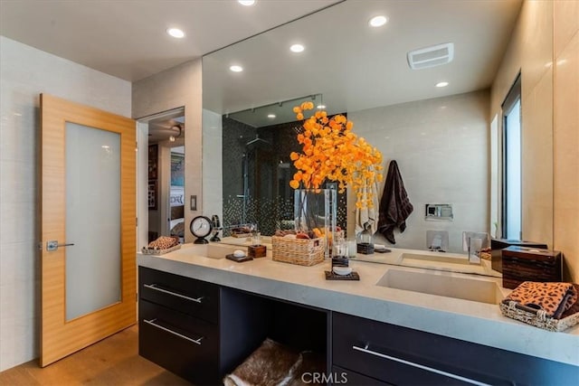 bathroom with wood-type flooring, vanity, and a shower with shower door