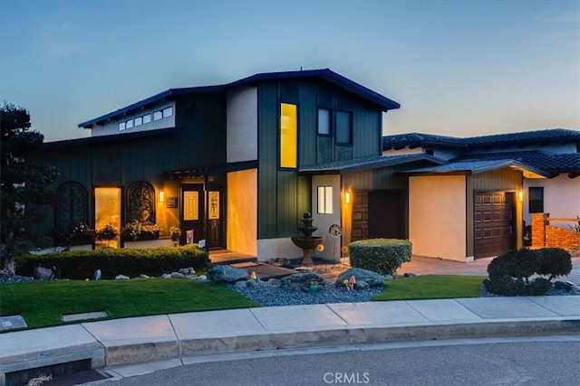 view of front of home featuring a garage and a lawn