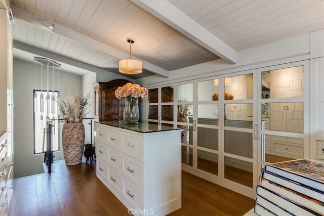 walk in closet featuring dark hardwood / wood-style floors and beam ceiling