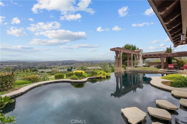 view of pool with a water view and a pergola