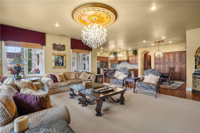 carpeted living room featuring a chandelier