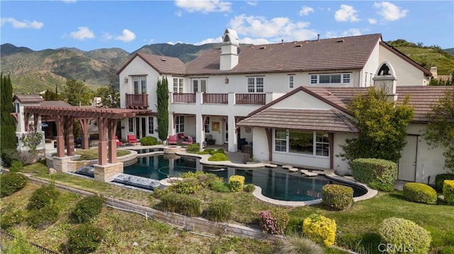 back of house with a pergola, a patio area, and a mountain view