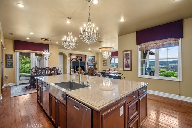 kitchen featuring sink, dishwasher, an island with sink, and plenty of natural light