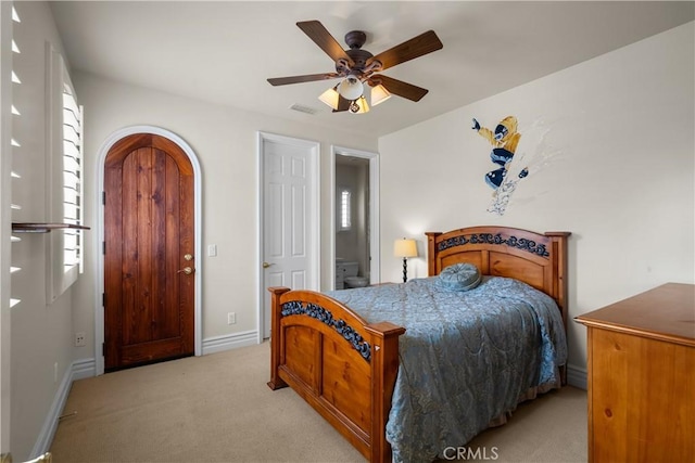 carpeted bedroom with ceiling fan and ensuite bath