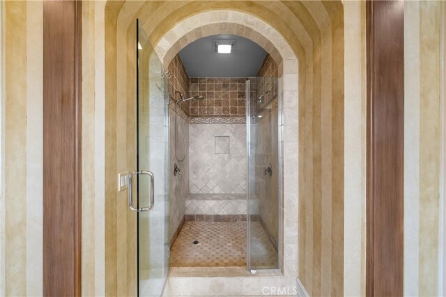 bathroom with a shower with door