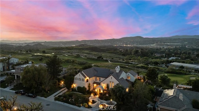 aerial view at dusk featuring a mountain view