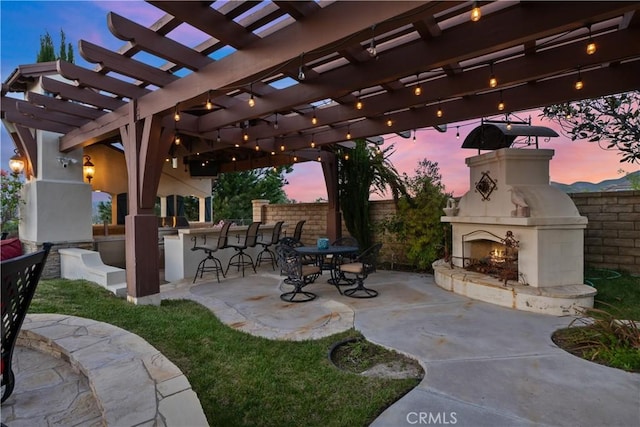 patio terrace at dusk with an outdoor fireplace, a pergola, and an outdoor bar