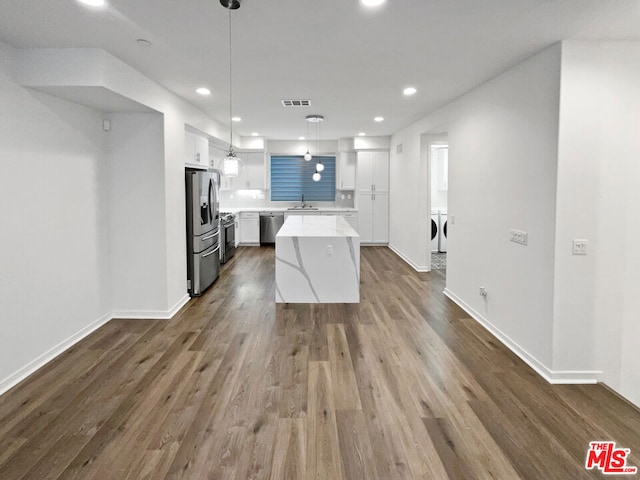 kitchen featuring light stone countertops, wood-type flooring, decorative light fixtures, a center island, and white cabinetry