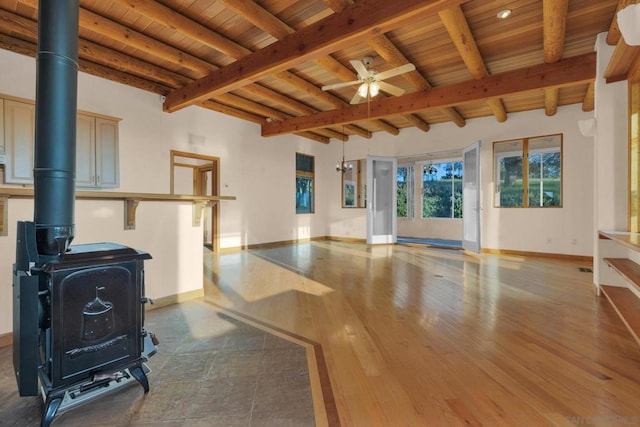 interior space featuring wooden ceiling, hardwood / wood-style floors, a wood stove, beamed ceiling, and ceiling fan