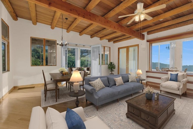 living room with wood ceiling, a healthy amount of sunlight, and ceiling fan with notable chandelier