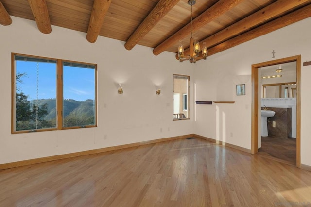 unfurnished room featuring a mountain view, beam ceiling, wood ceiling, hardwood / wood-style flooring, and a chandelier