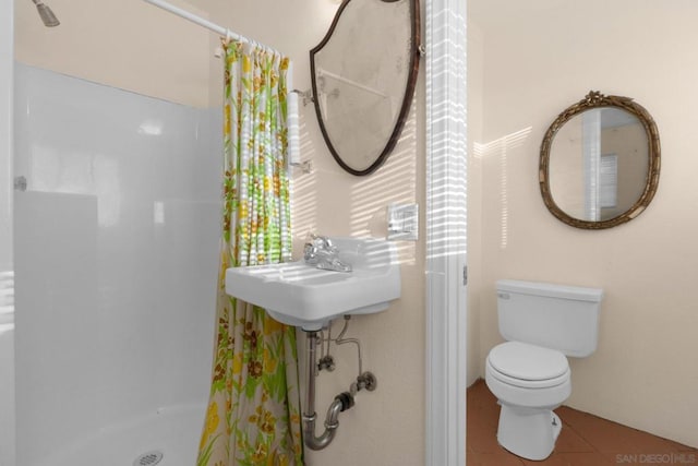 bathroom featuring tile patterned flooring, toilet, and curtained shower