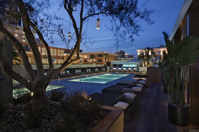 pool at dusk with a wooden deck