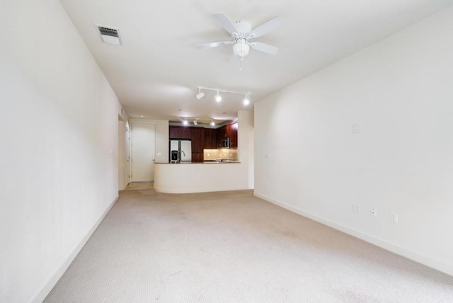 unfurnished living room featuring ceiling fan and light carpet