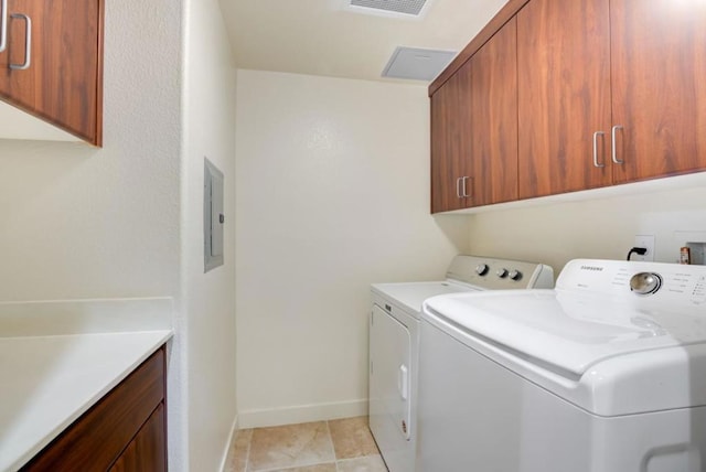 laundry room with cabinets, washer and dryer, and electric panel