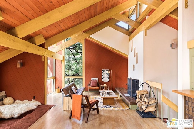 sitting room featuring a healthy amount of sunlight, wood-type flooring, lofted ceiling with beams, and wooden walls