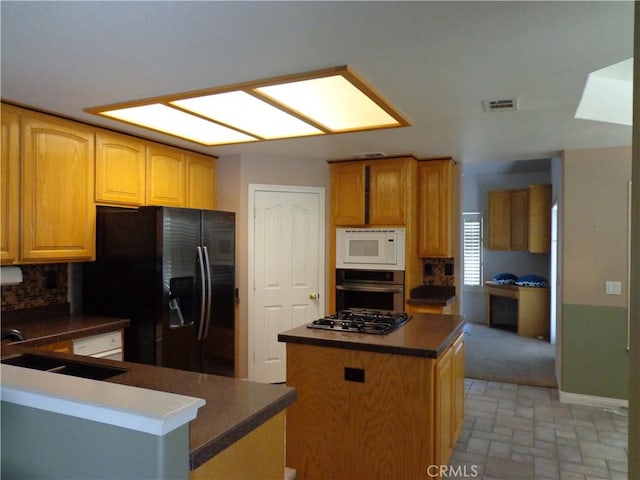 kitchen featuring backsplash, sink, a kitchen island, and stainless steel appliances