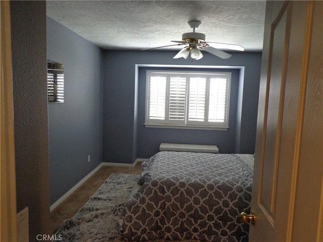 bedroom with ceiling fan, carpet, and a textured ceiling