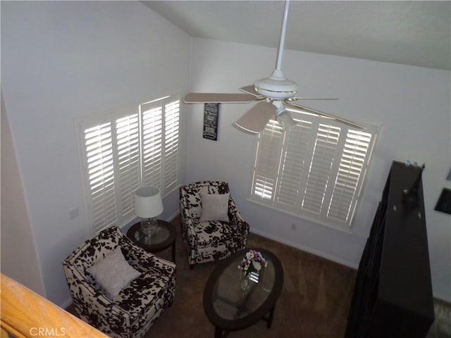 living area featuring ceiling fan, dark carpet, and vaulted ceiling