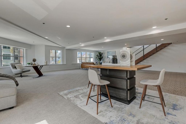 bar featuring vaulted ceiling, light colored carpet, and butcher block countertops