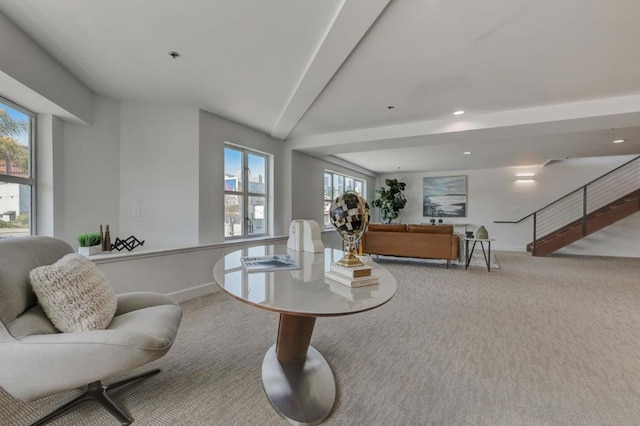 sitting room with beam ceiling and light carpet