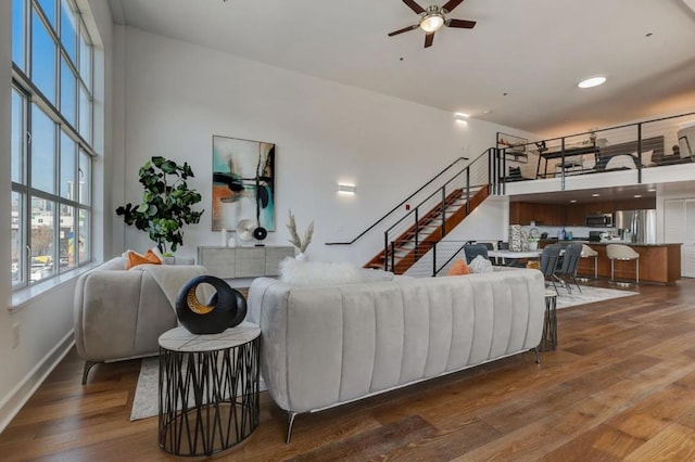 living room featuring ceiling fan and dark hardwood / wood-style flooring