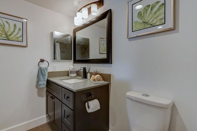 bathroom featuring toilet, vanity, and tile patterned flooring