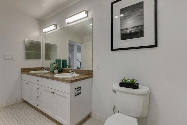 bathroom with toilet, vanity, and tile patterned floors