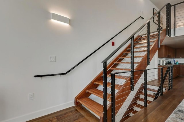 stairway featuring sink and hardwood / wood-style floors