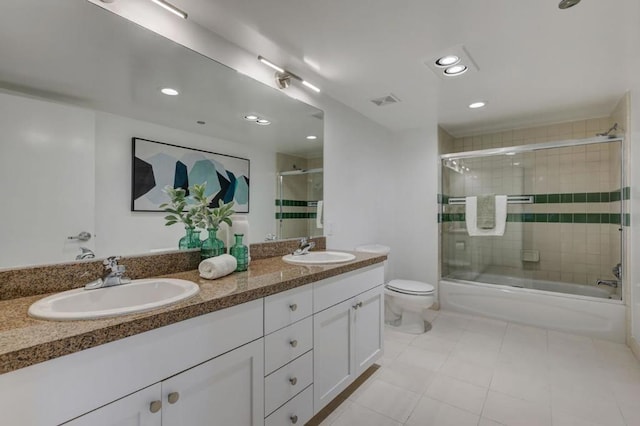 full bathroom featuring toilet, tile patterned floors, vanity, and shower / bath combination with glass door