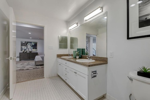 bathroom with toilet, tile patterned floors, and vanity