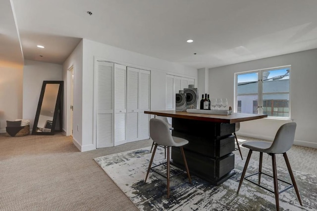 kitchen with washer and clothes dryer, a breakfast bar area, and carpet flooring