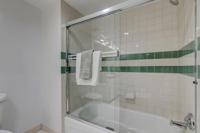 bathroom featuring shower / bath combination with glass door and toilet