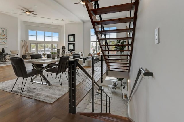 dining area with ceiling fan, a high ceiling, and hardwood / wood-style flooring