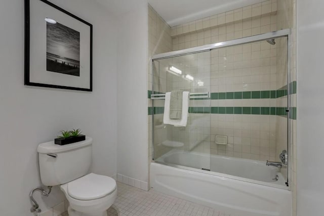 bathroom with toilet, bath / shower combo with glass door, and tile patterned flooring