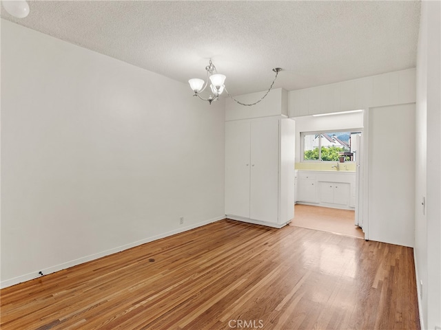 1901 Peyton Ave Unit T, Burbank, CA 91504 - spare room featuring wood-type flooring, a chandelier, and a textured ceiling