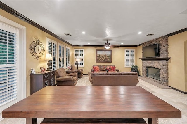 living room with ceiling fan, crown molding, and a fireplace