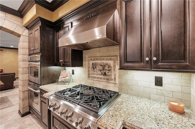 kitchen with range hood, stainless steel appliances, tasteful backsplash, and light stone counters