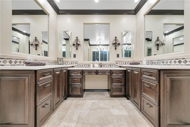 bathroom featuring vanity, crown molding, and a chandelier