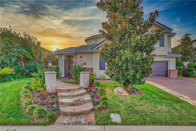 view of front of home with a yard and a garage