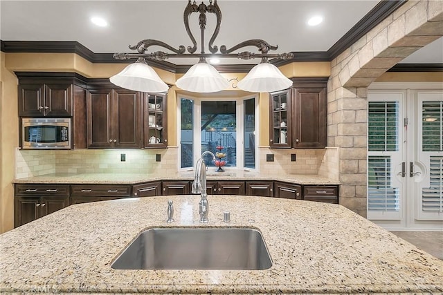 kitchen featuring light stone countertops, tasteful backsplash, and sink