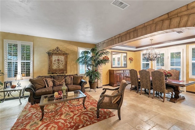 living room with a tray ceiling and a chandelier