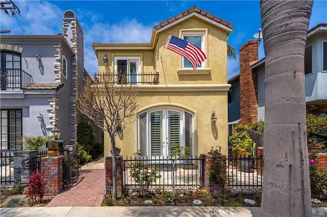 view of front of property featuring french doors and a balcony