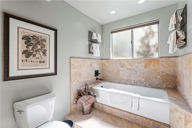 bathroom with a relaxing tiled tub and toilet