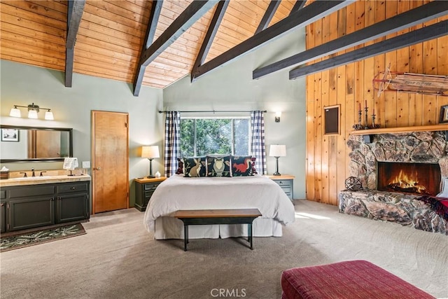 bedroom featuring high vaulted ceiling, ensuite bathroom, wood walls, and light carpet