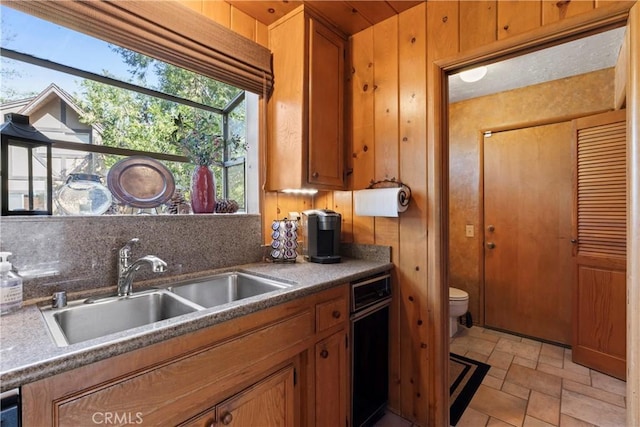 kitchen featuring sink and wooden walls